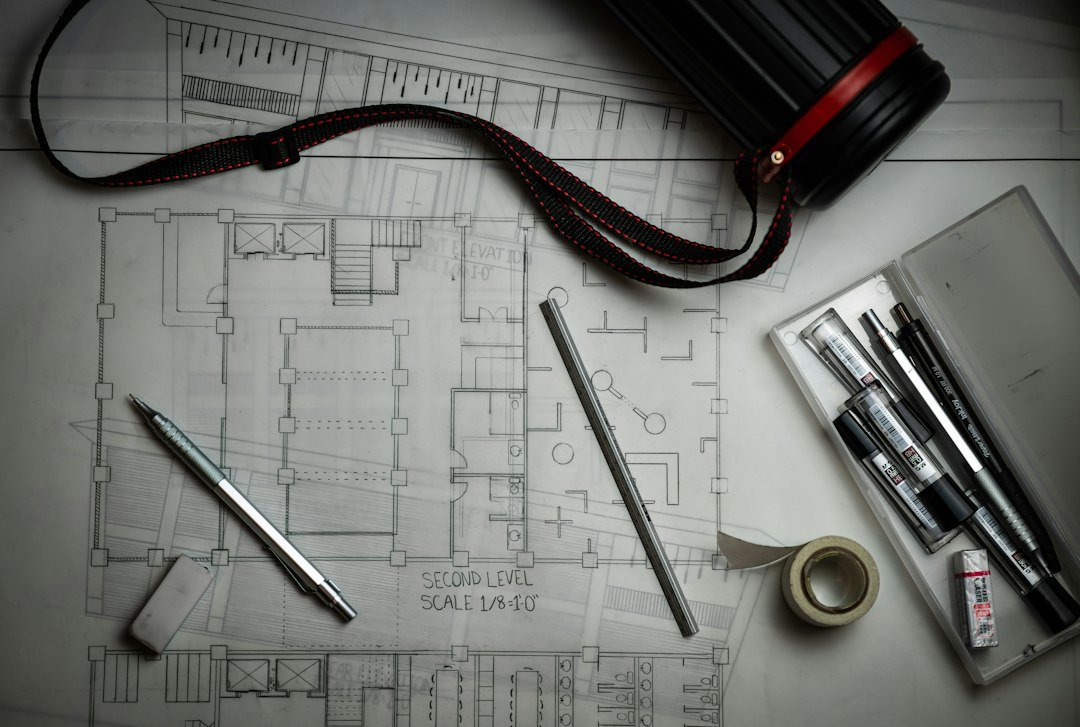 Role-themed stock image of architectural plans and drawing tools for the Building Surveyor vacancy in Hove