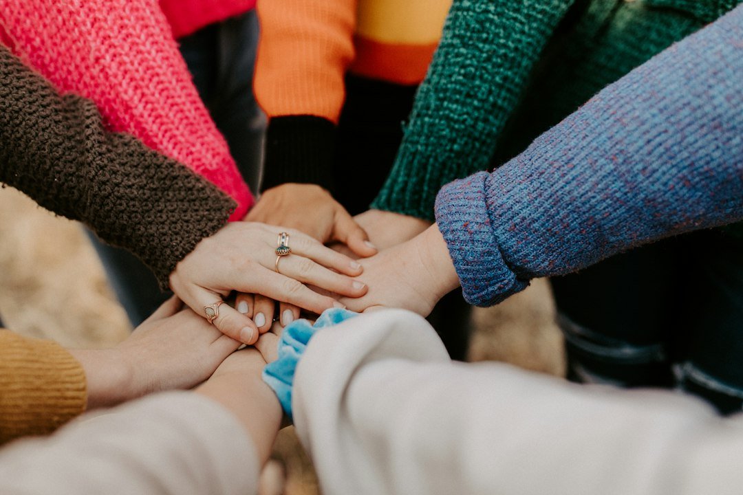 Role-themed stock image of hands joined in support for the Family Hub Support Worker vacancy in Brighton